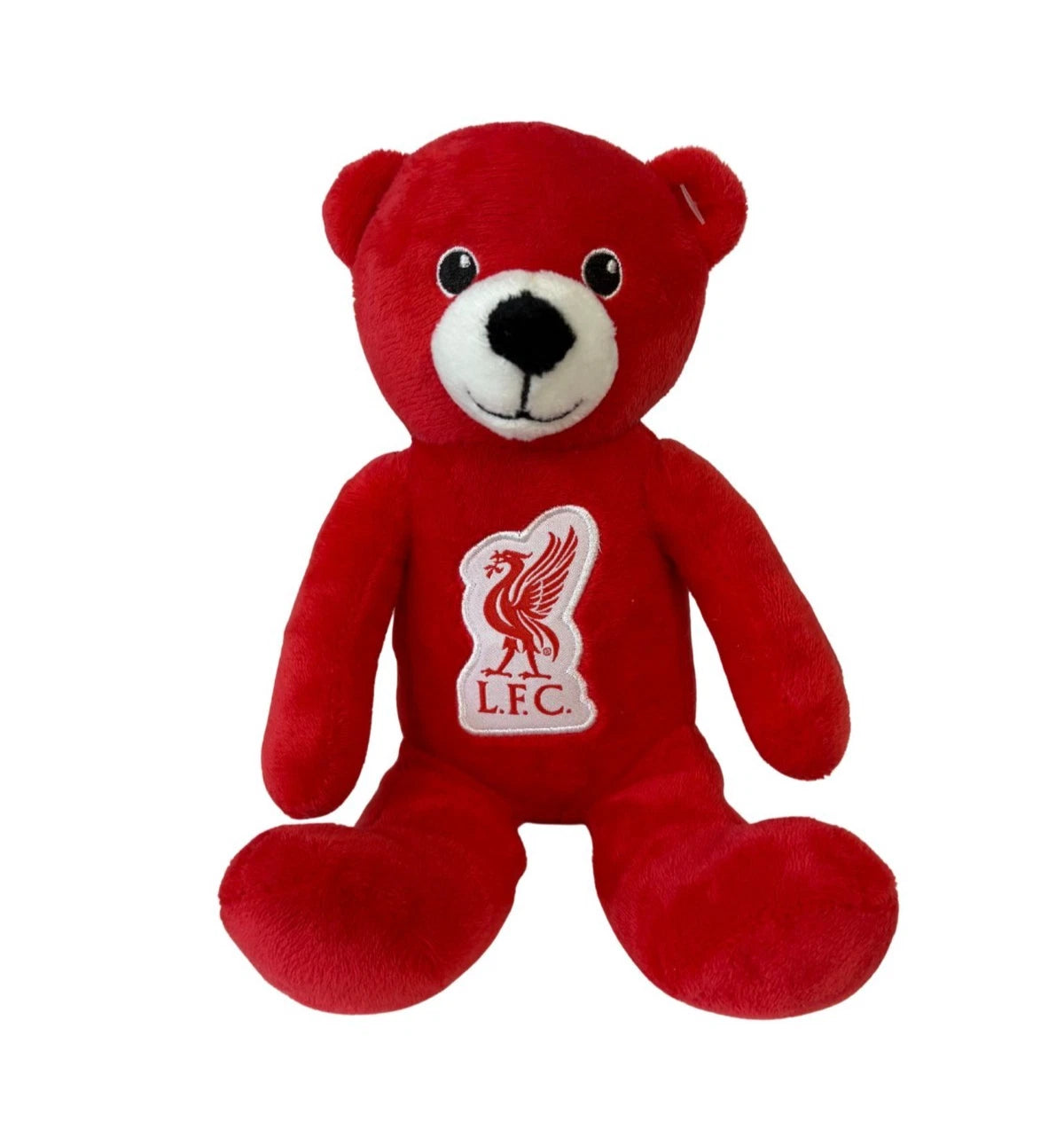 A red plush teddy bear with a white snout and black embroidered eyes, mouth, and nose. The bear features a Liverpool Football Club crest patch on its chest.